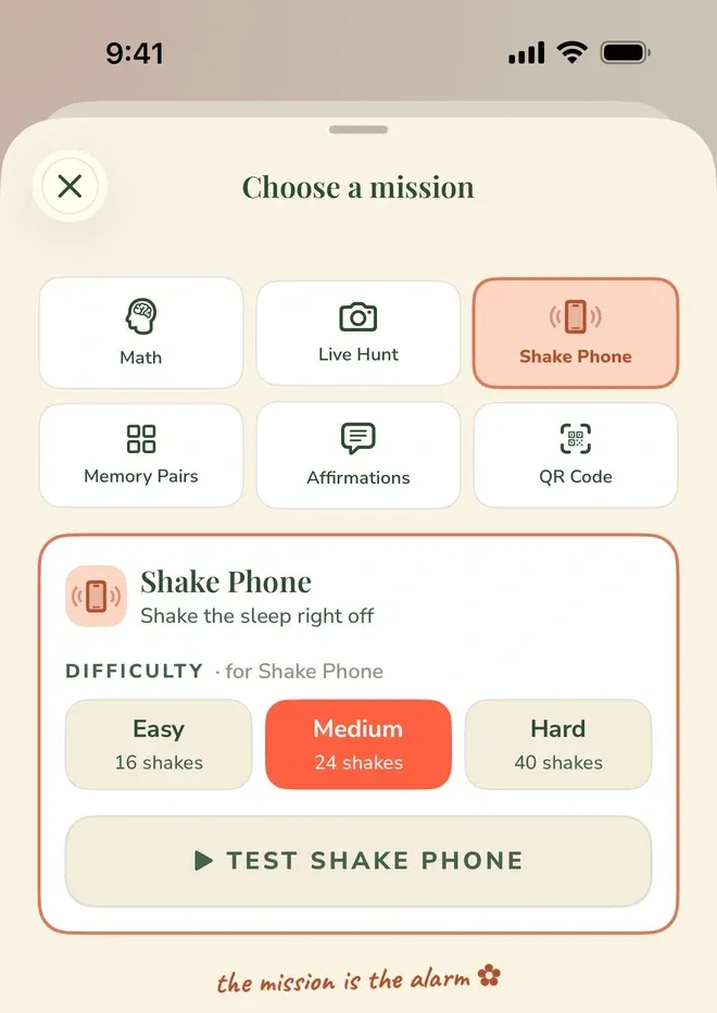A sheet headed “Choose a mission” shows six tiles — Math, Live Hunt, Shake Phone, Memory Pairs, Affirmations and QR Code — with Shake Phone selected. Beneath it, a row labeled “DIFFICULTY · for Shake Phone” offers Easy at 16 shakes, Medium at 24 (selected) and Hard at 40, above a “TEST SHAKE PHONE” button and the line “the mission is the alarm”.
