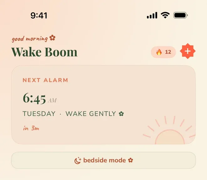 A home screen headed “good morning” and “Wake Boom”, with a flame badge reading 12 and an add button beside it. A “NEXT ALARM” card shows “6:45 AM”, “TUESDAY · WAKE GENTLY” and “in 3m”, above a “bedside mode” button.