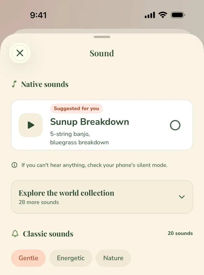 A sheet headed “Sound”. Under “Native sounds”, a card tagged “Suggested for you” offers “Sunup Breakdown”, described as “5-string banjo, bluegrass breakdown”, with a play button and an unselected circle, and beneath it the note “If you can’t hear anything, check your phone’s silent mode.” Below that, “Explore the world collection” holds “28 more sounds”, and “Classic sounds” is marked “20 sounds” with a row of three chips — Gentle (selected), Energetic and Nature.