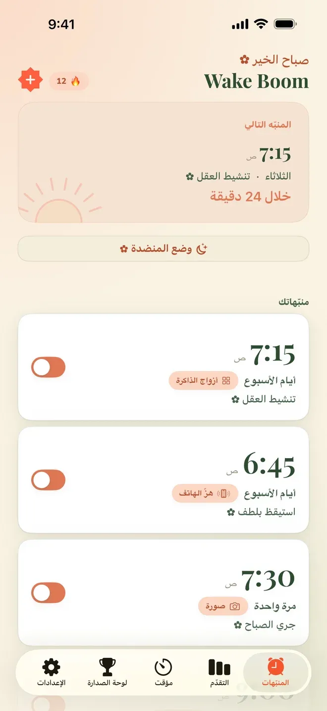 الشاشة الرئيسية في تطبيق Wake Boom بالعربية: بطاقة «المنبّه التالي» في الأعلى، وتحتها قائمة «منبّهاتك» فيها ثلاثة منبّهات لكل واحد وقته واسمه ومهمته — 6:45 «استيقظ بلطف» بمهمة هزّ الهاتف، و7:15 «تنشيط العقل» بمهمة أزواج الذاكرة، و7:30 «جري الصباح» بمهمة البحث المباشر