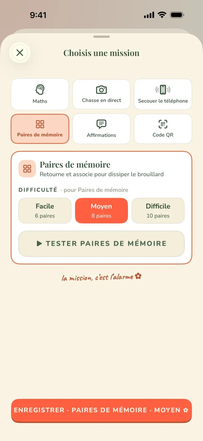 Écran du sélecteur de mission de l’application Wake Boom, en français, en mode portrait, barre d’état à 9:41. Titre : Choisis une mission. Une grille de six vignettes : en haut Maths, Chasse en direct, Secouer le téléphone ; en bas Paires de mémoire, Affirmations, Code QR. Paires de mémoire est sélectionnée et surlignée en rouge. En dessous, un panneau de détail pour Paires de mémoire : le nom, la ligne Retourne et associe pour dissiper le brouillard, puis une ligne Difficulté · pour Paires de mémoire avec trois choix, Facile / 6 paires, Moyen / 8 paires, sélectionné et rempli en rouge, Difficile / 10 paires, et un bouton Tester paires de mémoire. Sous le panneau, en écriture manuscrite de la marque : la mission, c’est l’alarme. En bas, un bouton rouge Enregistrer · Paires de mémoire · Moyen.