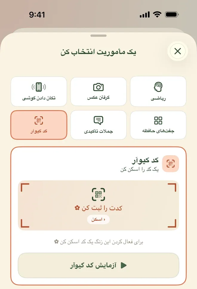 همان صفحهٔ انتخاب مأموریت با عنوان «یک مأموریت انتخاب کن»، این بار خانهٔ «کد کیوآر» انتخاب و نارنجی شده. کارت پایین «کد کیوآر» نام دارد با توضیح «یک کد را اسکن کن»، و داخلش کادری با گوشه‌های دوربین، نشان یک کد مربعی، نوشتهٔ «کدت را ثبت کن» و دکمهٔ کوچک «اسکن». زیر کادر نوشته «برای فعال کردن این زنگ یک کد اسکن کن» و پایین‌تر دکمهٔ «آزمایش کد کیوآر». بالای کارت همان شش خانهٔ مأموریت دیده می‌شود و چند جای متن نشان گل کوچک دارد.